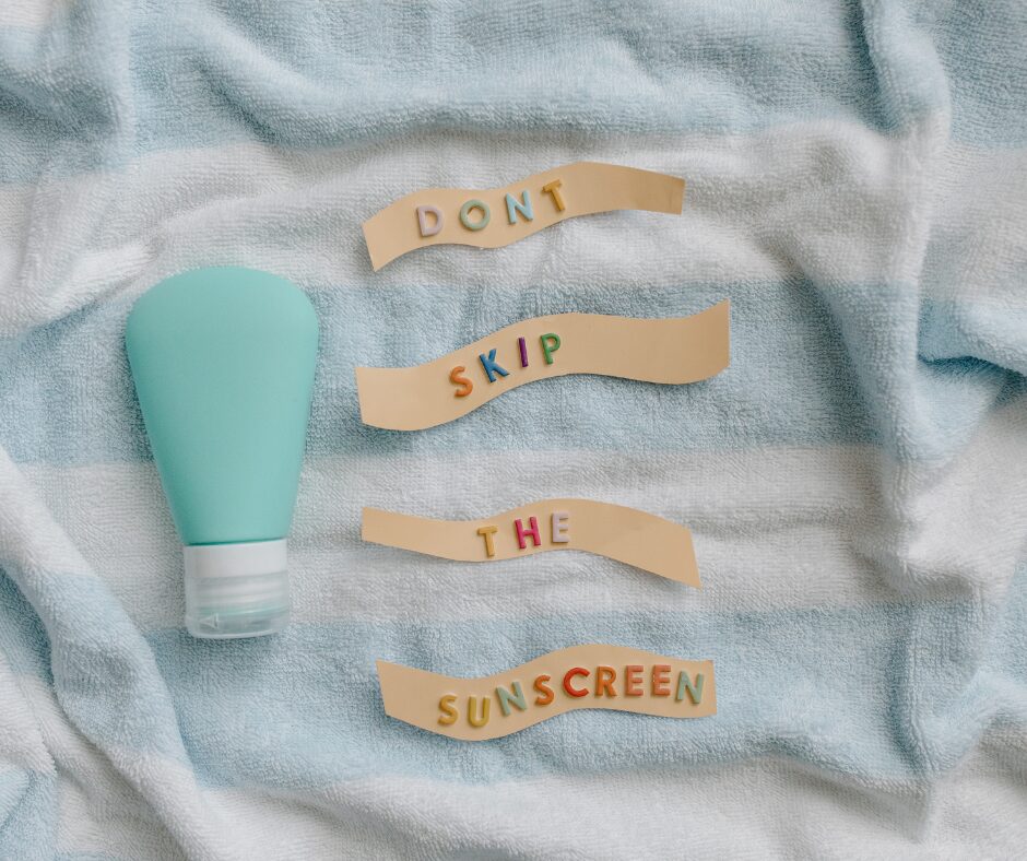 a sunscreen bottle on a towel with the words "Don't skip the sunscreen" next to it.