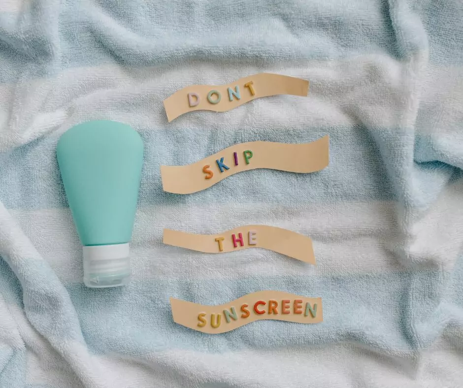 a sunscreen bottle on a towel with the words "Don't skip the sunscreen" next to it.
